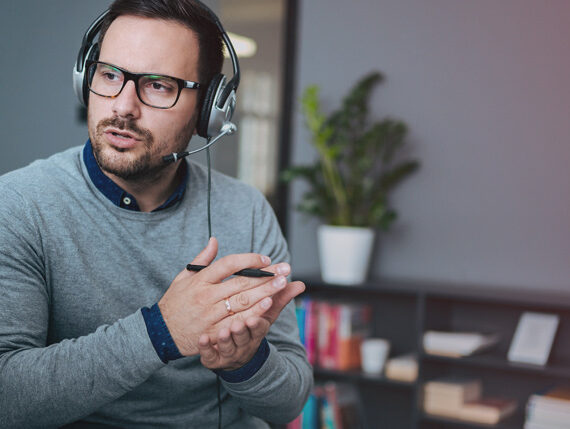 man talking on the phone using a headset and gesturing with his hands