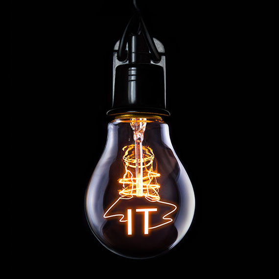 A light bulb set against a black background with the letters IT in yellow orange on top